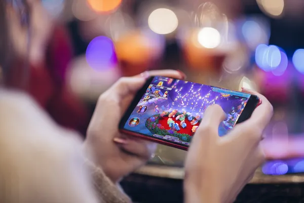 SLO16 App — Enjoy seamless gaming on your smartphone A young woman relaxing with her phone while dynamic casino elements float around her, illustrating the smooth mobile experience offered by the SLO16 app.