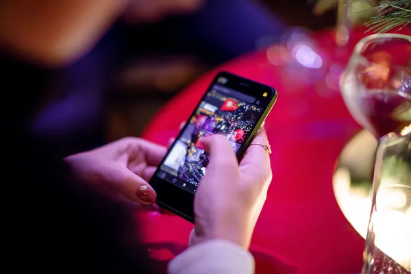 SLO16 App — Fast, responsive, and optimized for all devices A cheerful woman in traditional clothing using her smartphone during a festive moment, showing how easily the SLO16 app fits into everyday life.
