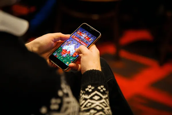 SLO16 Mobile App — Your complete hub for casino and sports A man focused on his laptop with live stats in the background, highlighting the dedicated sports and gaming features of the SLO16 mobile app.